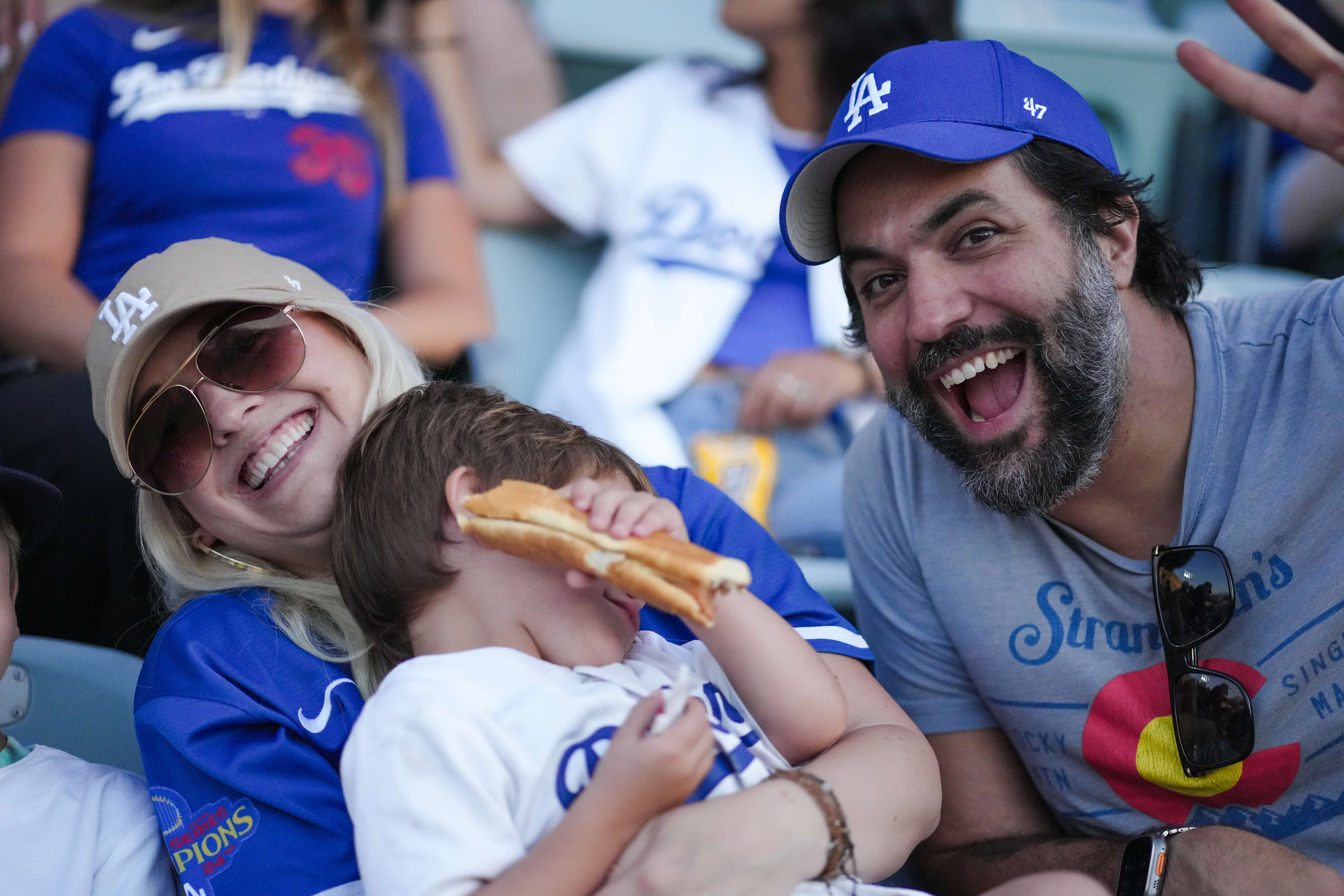 Family laughing in the stands with a hot dog
